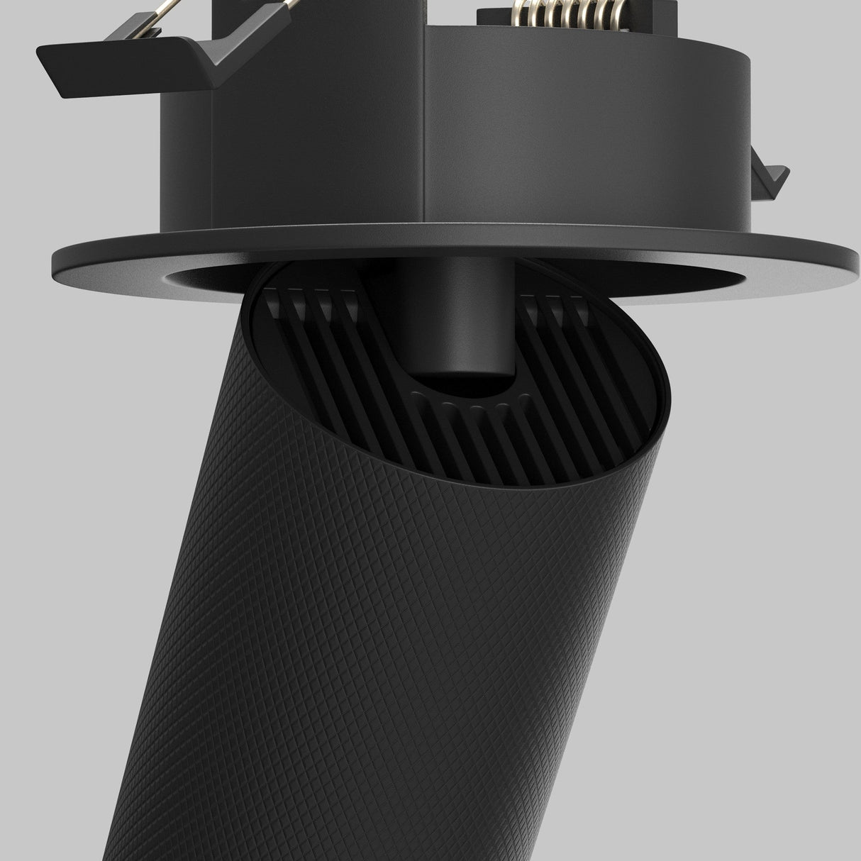 The Artisan Single Tilt Round Recessed Downlight in black features a modern cylindrical design with textured surfaces and visible hardware, set against a neutral gray background.