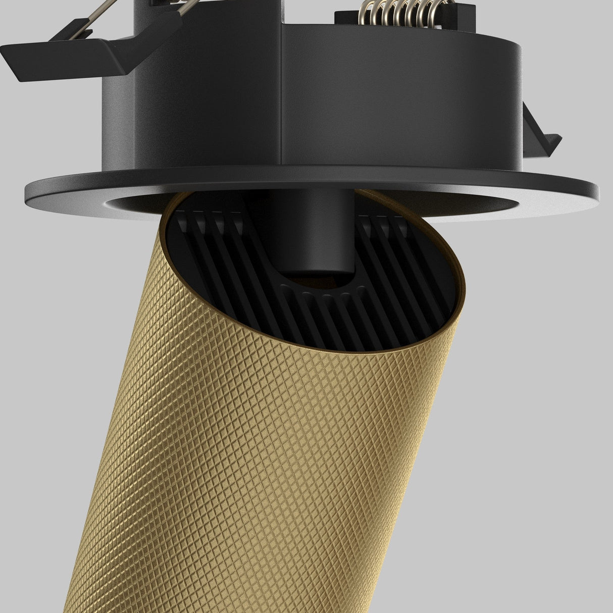 Close-up of the Artisan Single Tilt Round Recessed Downlight in matte gold, featuring a textured design on a stand. The light gray background highlights its modern elegance.
