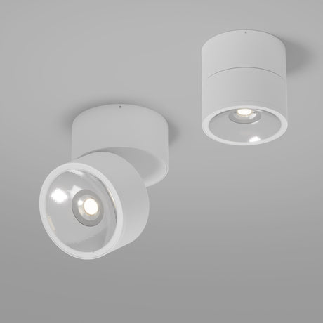 The Spin Outdoor LED Single Spotlight, with a modern cylindrical design and IP54 rating, provides a warm 3000K glow. One angles slightly, the other faces downward, and their white casings against the gray ceiling enhance a contemporary style.