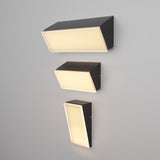 Three Brick Outdoor LED Wall Lights in graphite, mounted vertically on a gray wall, feature illuminated white faces. Each fixture varies in size for a harmonious outdoor design with energy-efficient lighting.