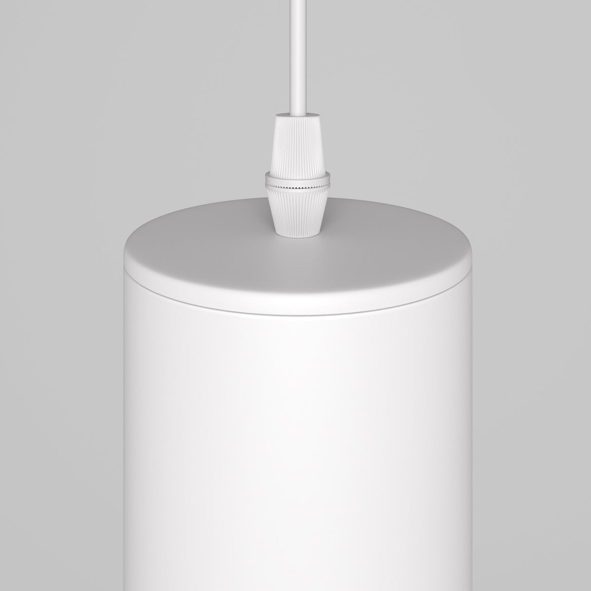 Close-up of the Lipari Short Round Pendant Lamp - White With Gold, a minimalist cylindrical design hanging from the ceiling. Its smooth surface and simple white cord cast a warm glow against a light gray background.