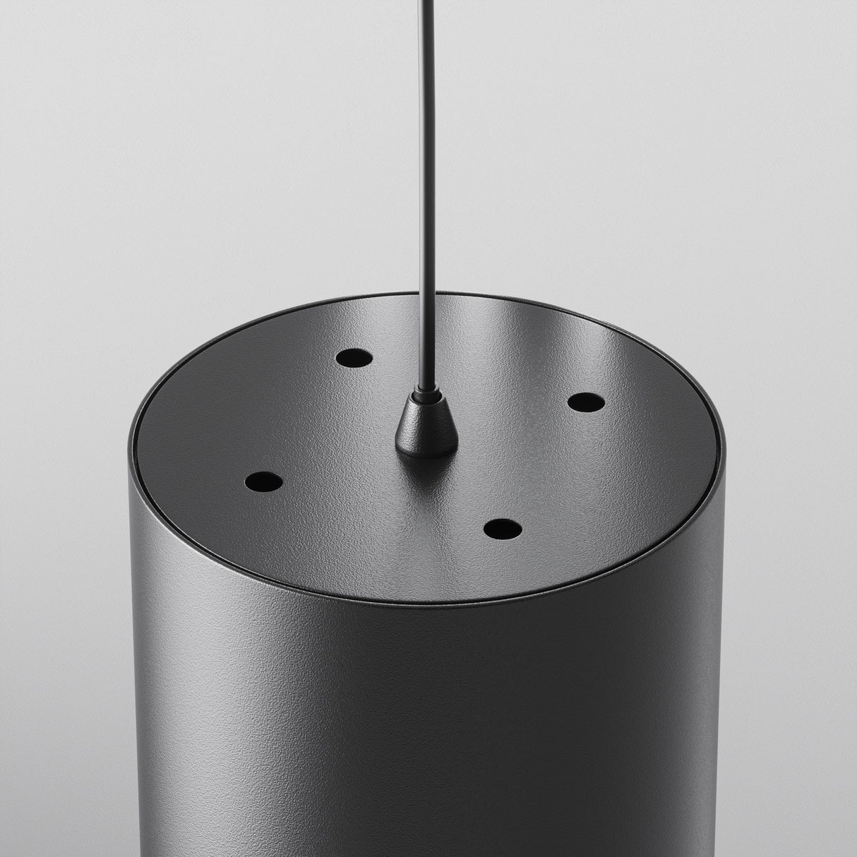 Close-up of the Polar Short Round Pendant Light - Black, featuring five top holes. Suspended by a thin cable, its minimalist and contemporary design adds a modern touch to any space.