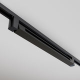 Close-up of the black Points Rot LED Swivel Linear Track Light installed on a white ceiling. This modern, minimalist fixture has clean lines and an elongated design parallel to the ceiling, emitting warm 3000K light.
