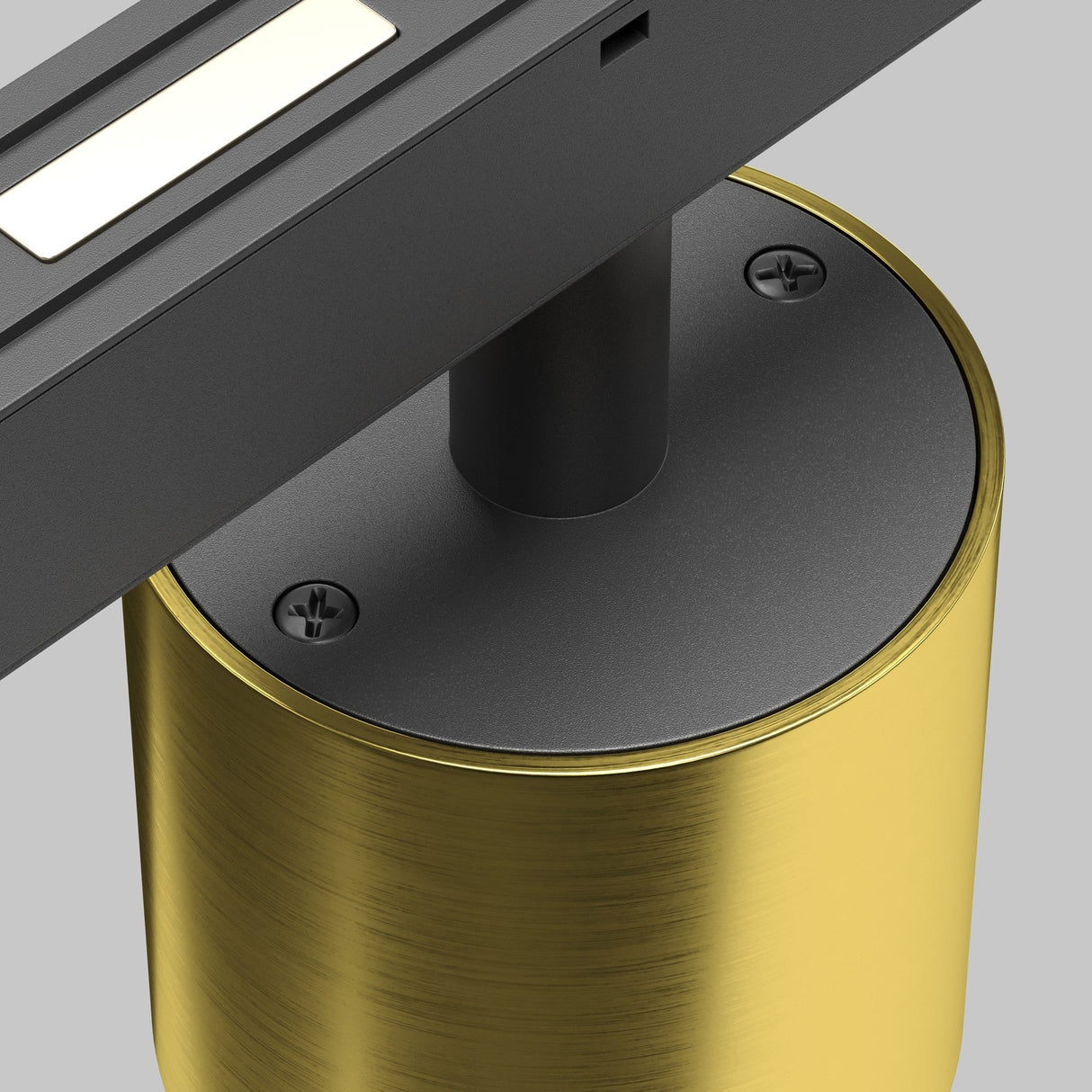 Close-up of the Alfa S CCT LED Dimmable Magnetic Exility Track Downlight 7W 2700-6000K in brass, featuring a cylindrical base with two visible screws and a horizontal bar housing a small recessed downlight. The textured brushed metal stands out against the neutral gray background.