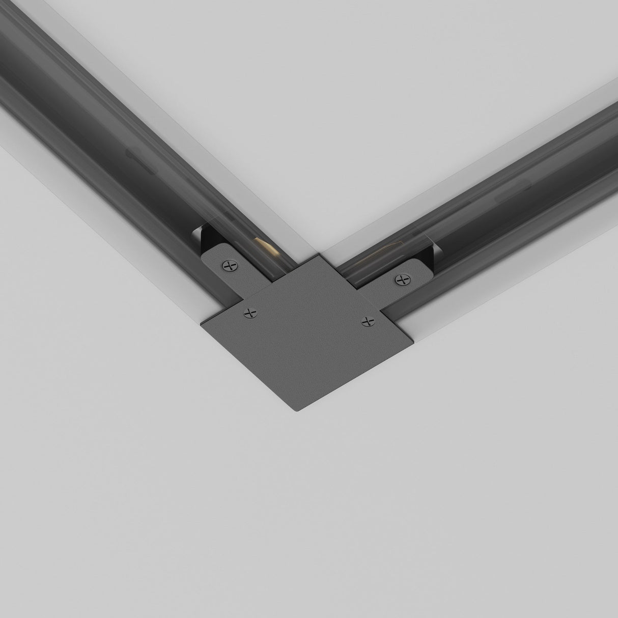 Close-up of the Unity Tracks Recessed L-Shaped Connector - Black joining two perpendicular metal beams with visible screws on a neutral gray background, ideal for contemporary spaces.