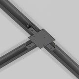 Close-up of a Unity Tracks Recessed T-Connector - Black, seamlessly joining translucent beams on a smooth white surface, with a sleek cross-shaped joint that enhances the elegance of the architectural detail.