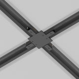Close-up of the black Unity Tracks Recessed X-Shaped Connector linking four beams at right angles on the ceiling. The dark gray beams converge neatly, secured by screws, creating a symmetrical intersection against the light gray background with seamlessly integrated track lighting.