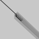 Close-up of the Exility Track Power Feed - Black (TRA034B-42B-1), a modern, suspended linear LED fixture with a black cable. The minimalist system boasts a sleek silver finish, ideal for contemporary interiors against a light gray background.