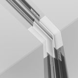 A close-up of a modern architectural ceiling detail reveals the sleek, minimalist design of the Exility Tracks Internal Corner Connector. Sharp lines and angles are illuminated by recessed track lighting, enhancing overlapping layers of white and gray materials for added depth and precision.
