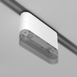 The Radity Magnetic Track Short Adaptor in white features a minimalist rectangular design with visible internal components and screws, perfect for modern interiors when mounted on a ceiling track, elegantly complementing a light gray background.