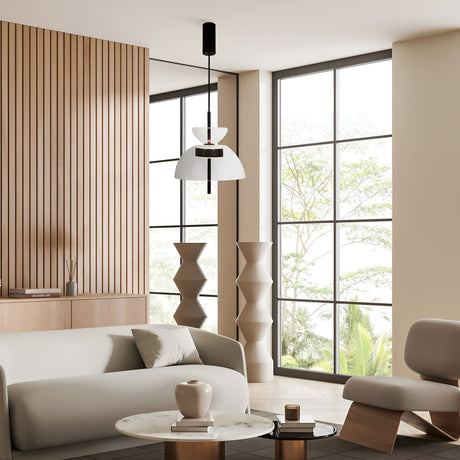 A modern living room with contemporary interiors features minimalist design, a light gray sofa, round marble coffee table, and sleek armchair. Large windows illuminate geometric sculptures and wooden wall paneling, while the Bangkok LED Pendant Light 25cm - Black With Clear Glass Shade hangs above.