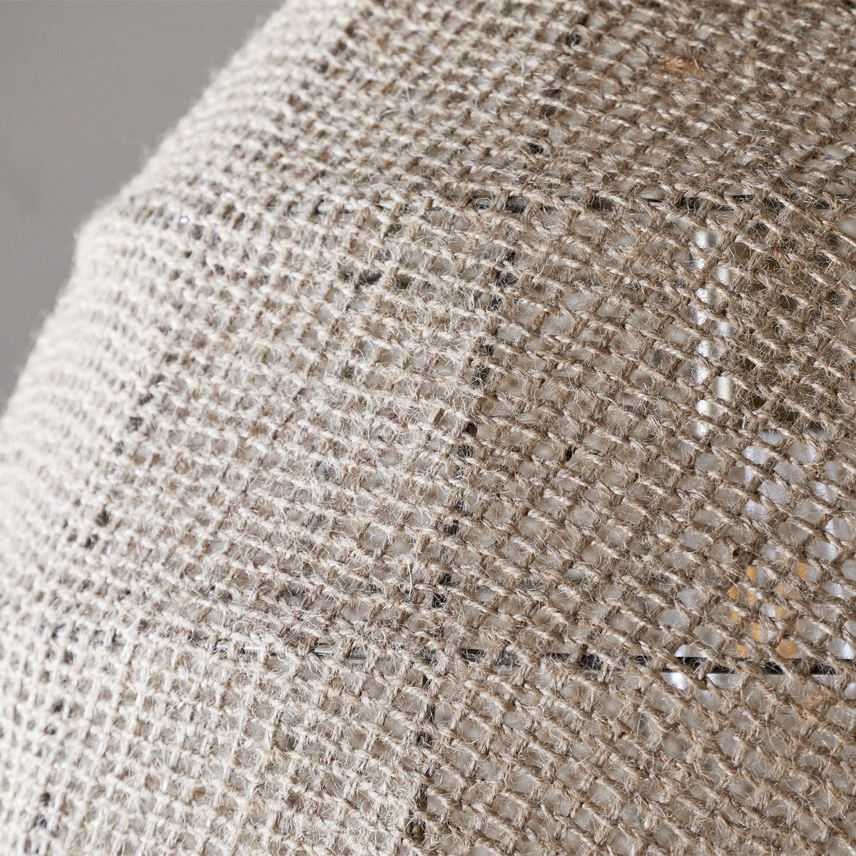Close-up of the Jahari Woven Jute Pendant Light's natural open-weave dome, showing coarse knotted jute fibre with visible stitched seam panels.