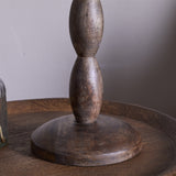 Close-up of the Konali table lamp base in ash stain mango wood, showing the turned, bead-like spindle column on a round disc foot against a neutral background.