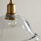 Close-up of the Keju recycled glass pendant light showing its wide shallow clear glass bell with rippled rim and brass collar, fitted with an exposed bulb.