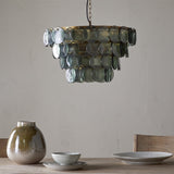 Kagitha Large 3 Light Recycled Glass Chandelier in Green, tiered round glass discs on a brass frame, hung in a dining room above a table with ceramic tableware.