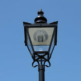 Large Victorian replacement lantern head in black metal with a pointed finial and glass panels, shown against a plain blue sky, for 77mm post fitting.