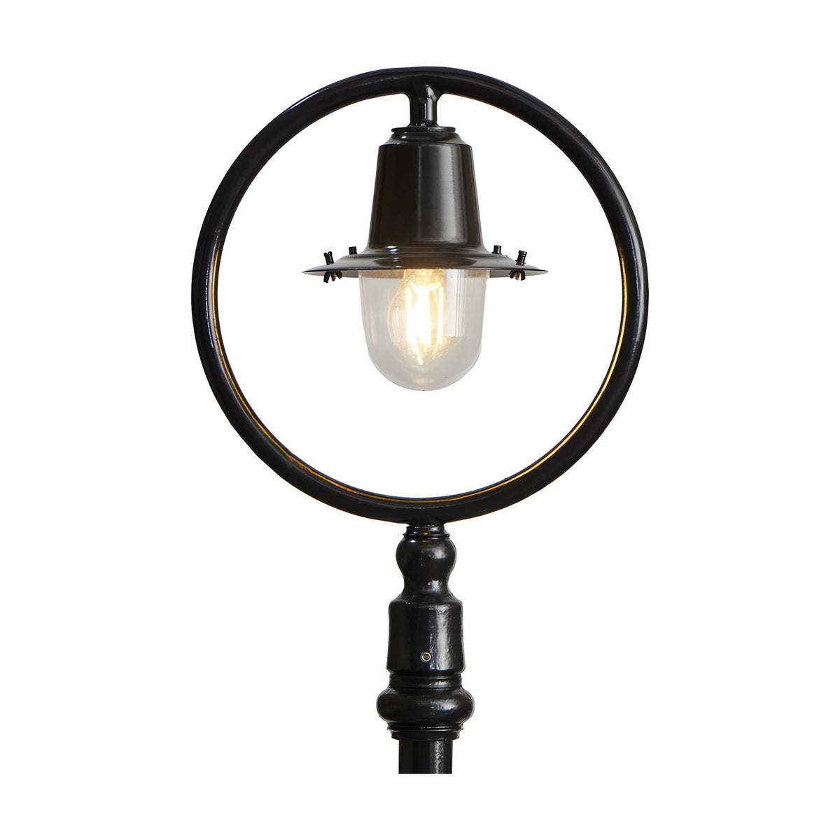 Cast iron railway lantern head in black with clear glass shade and visible bulb, shown mounted within a black hoop and post for scale on a plain white background.