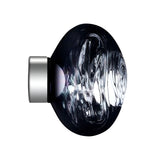 A round, dark, glossy Lava Small LED Wall & Ceiling Light in Smoked Blue with a swirling glass-like texture and a Smoked Silver metallic cap on the left, set against a white background.