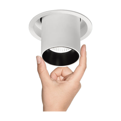 Garda Recessed Downlight, 95mm cut-out, matt white body with a black aperture ring and tilting LED head, shown held in hand against a plain white background.