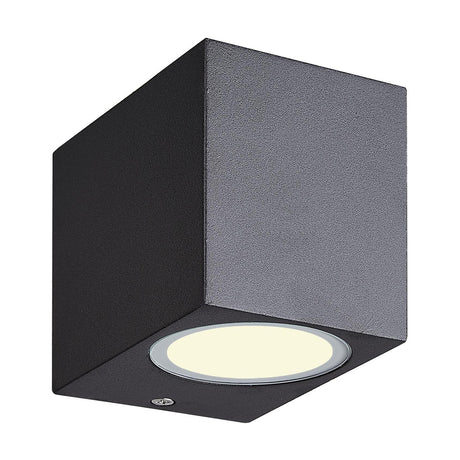 Kandanchu IP54 outdoor wall light, a compact cuboid fixture in sand black aluminium with a round frosted glass diffuser on the lower face, shown on a plain white background.