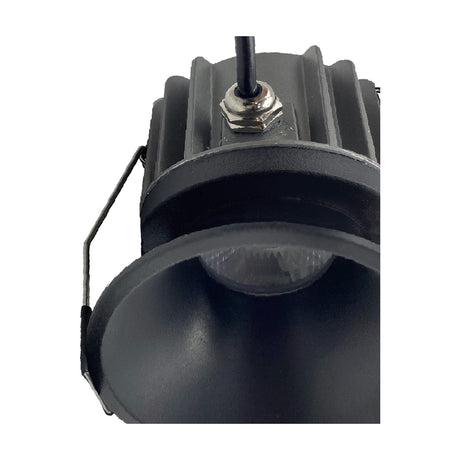 Close-up of Rombok 8W LED downlight in black aluminium, showing the recessed round housing, finned heat sink, wiring lead, and CCT-adjustable switch on a white background.