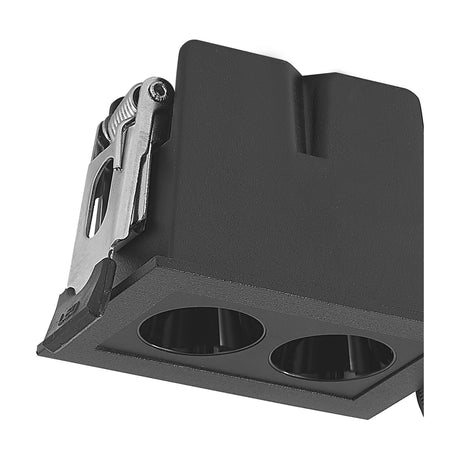 Close-up of the Blau 2 Light Downlight in black aluminium, showing the rectangular bezel with two round recessed apertures and the spring clip fixing mechanism, on a plain white background.