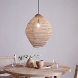 Mukuni Large Wire Lampshade in brass-toned knitted mesh, lantern-shaped with a full belly, hung as a pendant light above a round wooden dining table.