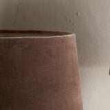 Close-up of the Mendai Small Velvet & Linen Lampshade in mocha, a tapered drum with washed velvet pile and a pale natural linen band at the top rim.