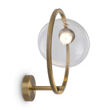 Lunare brass and clear glass wall light shown on a wall, highlighting its reflective and elegant design.