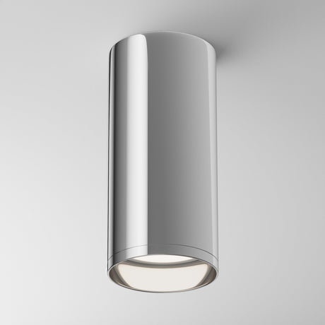 The Focus Fixed Round Surface Mounted Downlight in chrome features a polished, cylindrical design. Perfect for modern settings, it emits bright white light downward, enhancing any white ceiling background.