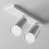 The Focus S Twin Bar Spotlight - White is a modern, minimalist fixture with two adjustable cylindrical white lights on a rectangular base, emitting a soft glow that blends seamlessly with the ceiling.