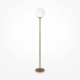 The Ring Floor Lamp in brass showcases a frosted glass globe shade, standing elegantly on a circular base against a plain white background, making it a chic modern addition to any space.