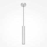The Pro Focus Thin Pendant Light - Silver features a sleek, minimalist cylindrical design, suspended by a thin black cord from a round ceiling mount. With its polished silver finish, it embodies modern design against a plain white backdrop.