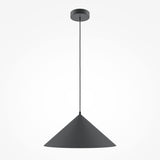 A Basic Colors Cone Pendant Light - Black, featuring a minimalist dark gray cone, hangs from a thin black cord attached to the ceiling. Its modern design offers beautiful contrast against a plain white background.