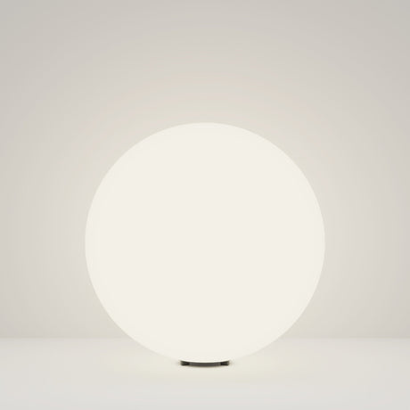 The 49cm Erda Pedestal Light in white, with its modern design and illuminated round form, emits a soft glow on a plain surface, enhancing outdoor lighting with understated charm.