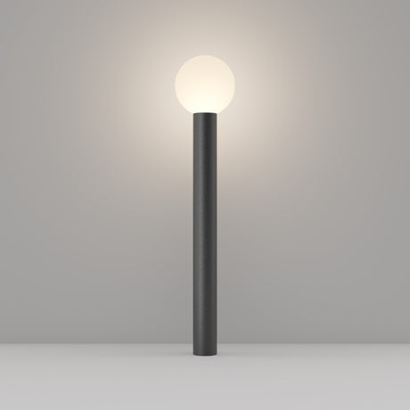 The Bold Bollard Light 80cm - Black boasts a sleek, dark aluminium cylindrical base and a glowing white spherical bulb, resembling an elegant bollard light. It presents beautifully against a plain grey background.