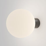 The Bold Outdoor Wall Light - Black (O598WL-01B1) features a minimalist design with a spherical frosted glass shade that emits a soft, warm glow. Its IP65-rated dark circular base ensures durability and ambiance, making it perfect for modern outdoor settings.