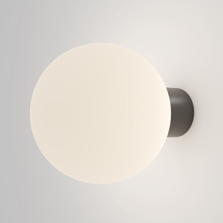 The Bold Outdoor Wall Light - Black (O598WL-01B1) features a minimalist design with a spherical frosted glass shade that emits a soft, warm glow. Its IP65-rated dark circular base ensures durability and ambiance, making it perfect for modern outdoor settings.