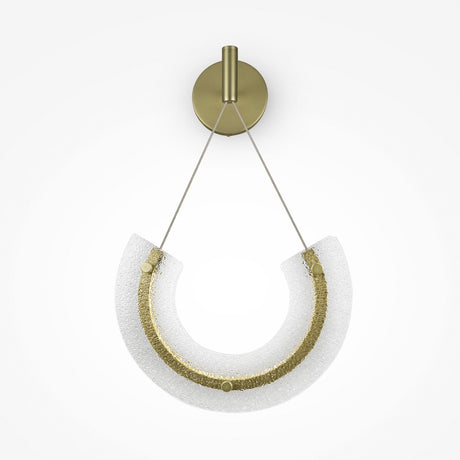 The Maya LED Wall Light features a semi-circular design with energy-efficient technology, clear textured glass, a darker glittery inner arc, and is suspended by two thin wires from a round gold mount.