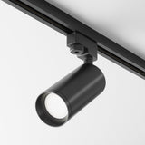 The Focus Single Phase Unity Track Spotlight - Black, with its sleek cylindrical pivoting head, mounts on ceilings for adjustable lighting direction. It uses GU10 light bulbs to ensure visual comfort against a plain white ceiling backdrop.