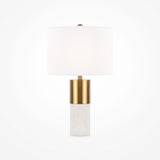 The Bianco Table Lamp - Brass & Alabaster With White Round Shade radiates modern elegance with its cylindrical shade and exquisite base, set against a plain white background.