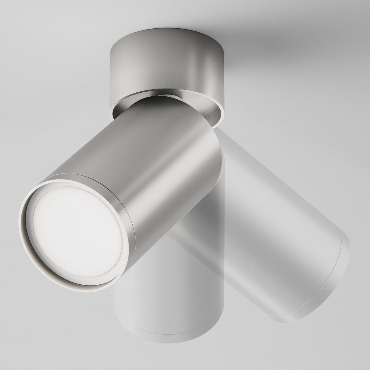 The Focus S Single Surface-Mounted Spotlight - Silver is a ceiling-mounted, cylindrical LED light with a sleek modern design and matte silver finish. It features an adjustable head for directional illumination, set against a plain white background.