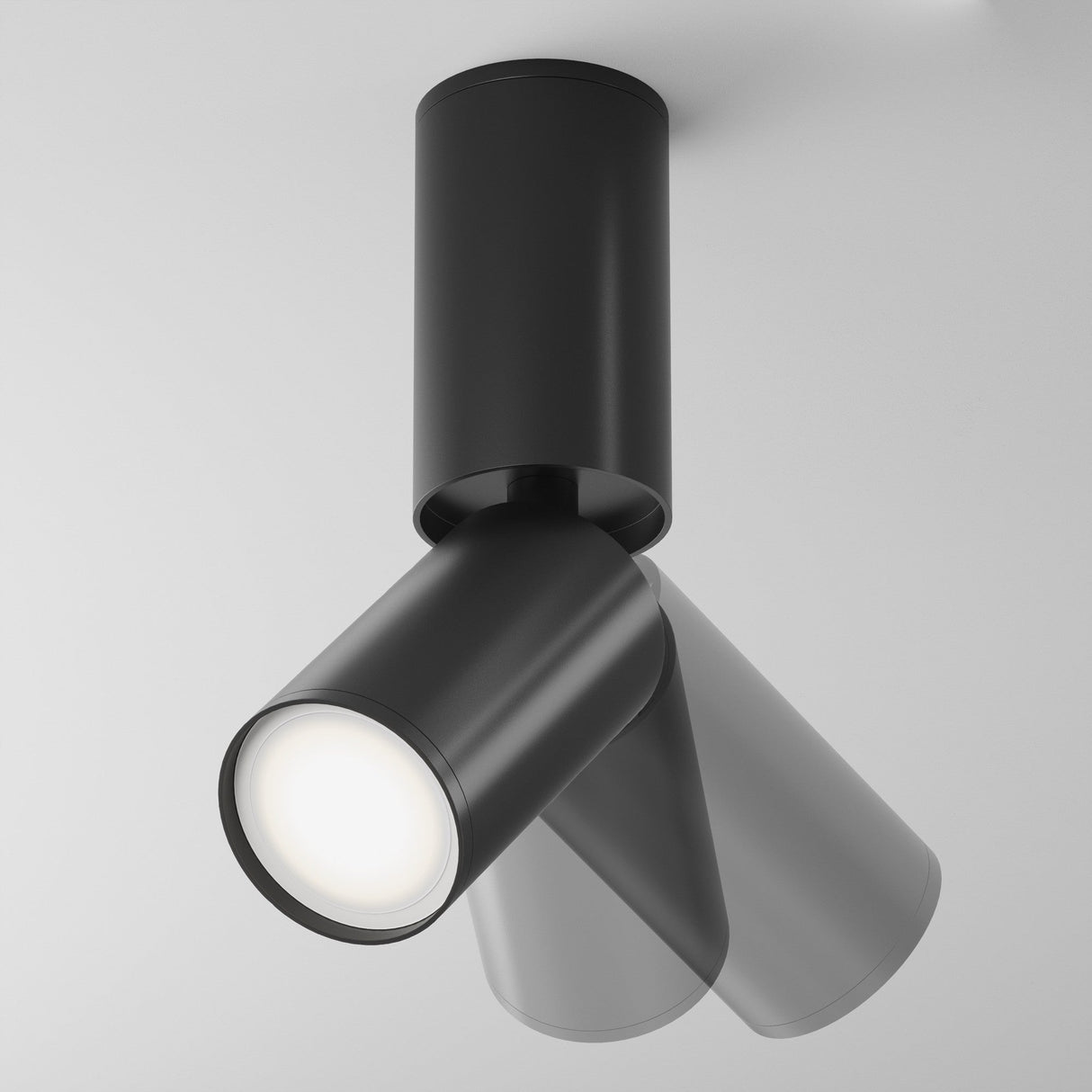 The Focus S Long Single Surface-Mounted Spotlight in black, featuring an adjustable head for white light illumination, stands out against a plain gray background.