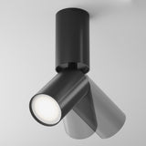 The Focus S Long Single Surface-Mounted Spotlight in black, featuring an adjustable head for white light illumination, stands out against a plain gray background.