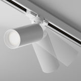 The Focus 3-Circuit Trinity Track Spotlight - White features a GU10 base and mounts on a ceiling rail. Its overlapping positions highlight its adjustable lighting, while the sleek design of both the ceiling and light emphasizes a modern aesthetic.