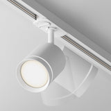 Close-up of the Orlo LED Single Phase Unity Track Spotlight 5W 4000K - White, featuring a cylindrical design. Mounted on a single-phase track system, it emits a soft glow at 4000K against a plain white ceiling, enhancing its minimalist aesthetic.