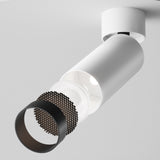 The Focus LED Single Surface-Mounted Spotlight 12W 4000K - White is a modern cylindrical ceiling light with a textured black front, ideal for contemporary interiors. It has a sleek, minimalist design with an energy-efficient grid-like pattern on the front.