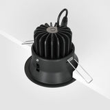 The Yin LED Dimmable Round Recessed Downlight 12W 3000K - Black features a ribbed heat sink, spring clips for ceiling installation, and a cable from the top for electrical connection.