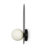 Introducing the Bao Wall Light - Black: a minimalist wall sconce featuring a round white bulb partially enclosed by a sleek black metal plate. Its elegant modern design is perfect for contemporary interiors.