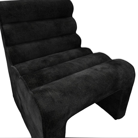 Nami Accent Chair in black velvet chenille, close-up of the ribbed, contoured backrest and curved seat with sculptural base on a white background.